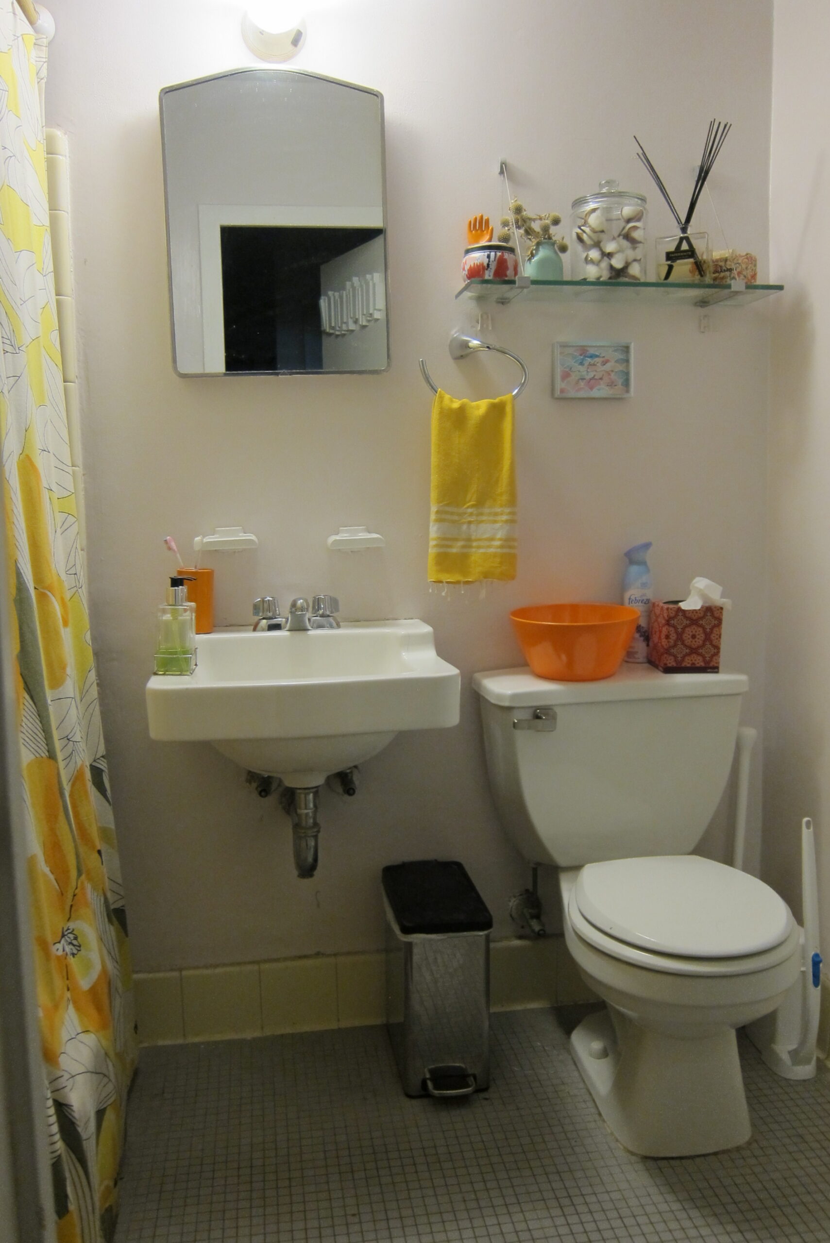 An old, dark bathroom with a basic sink, toilet, and shower curtain