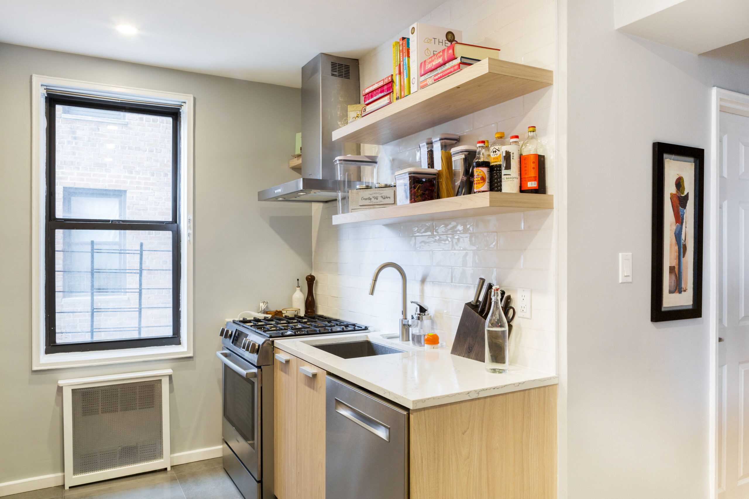 Ditmas Park kitchen remodel with light wood cabinets, white tile, open shelves, quartz counters, stainless appliances, and a cleaner cooking wall.