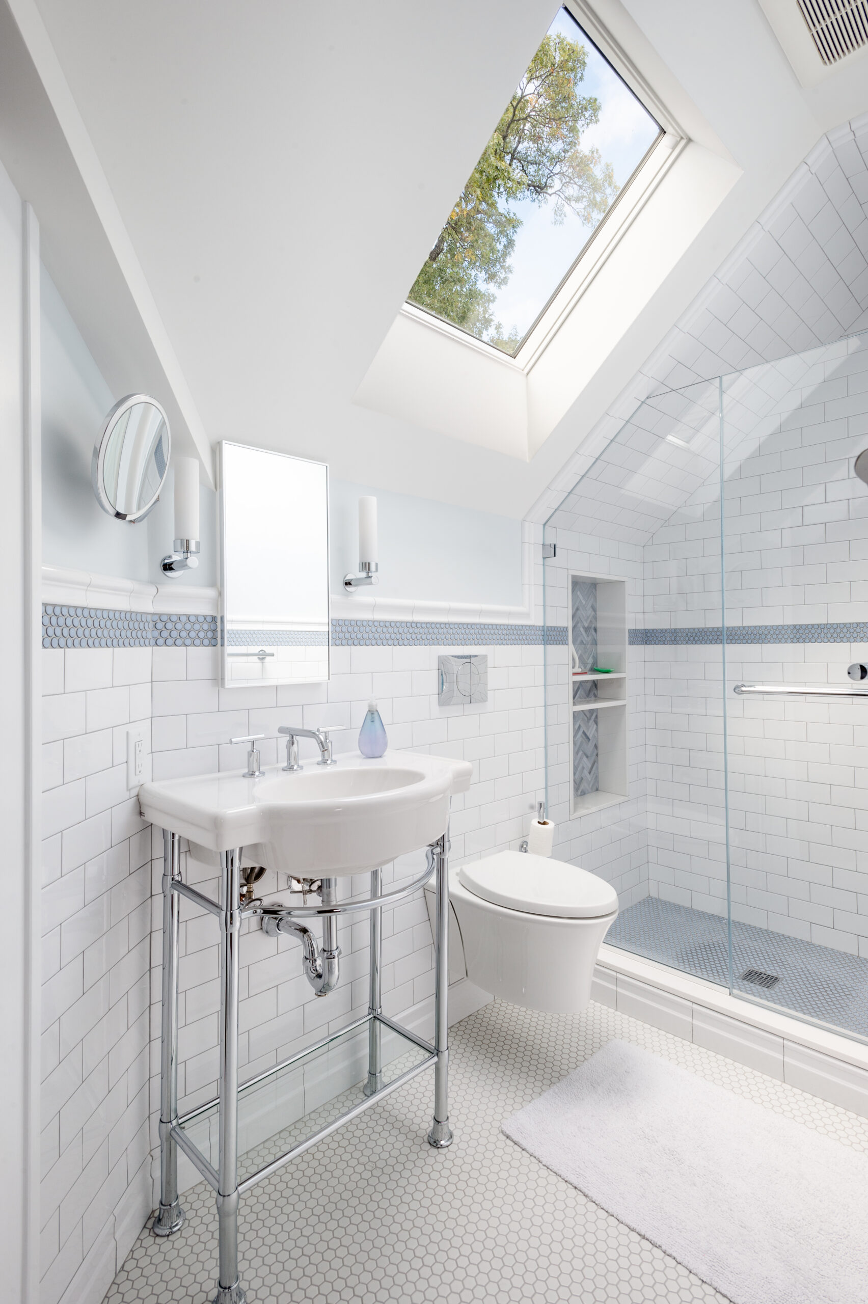 Pelham historic home renovation bathroom with skylight, white subway tile, blue accent band, glass shower, and console sink.