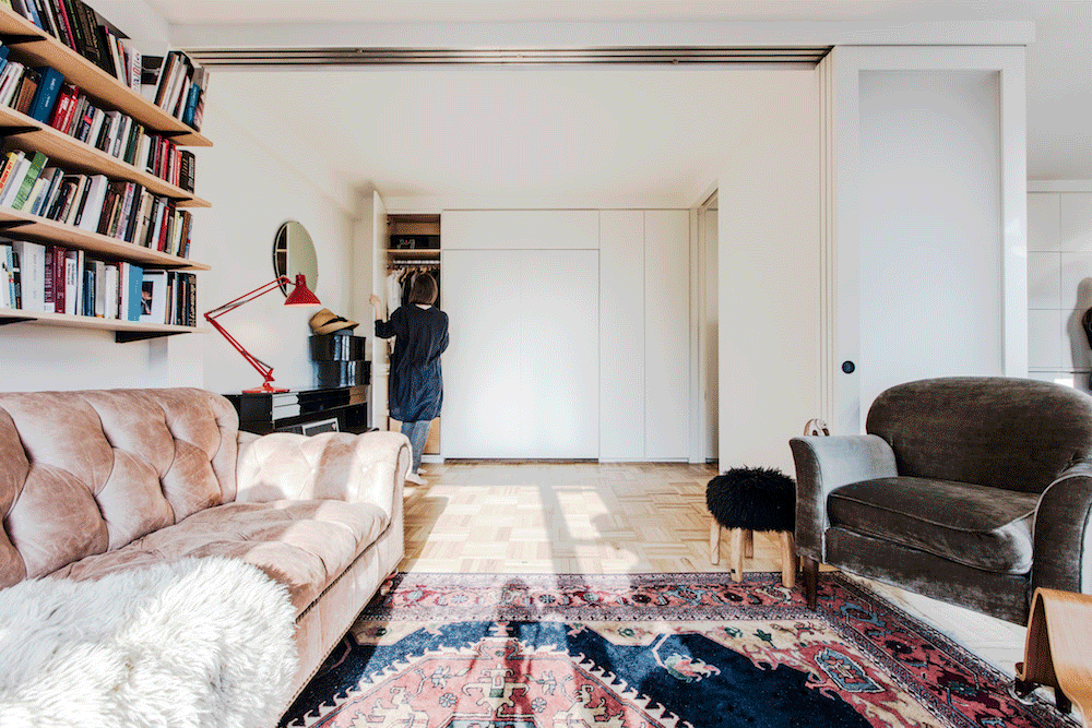 Retracting wall panels in Clinton Hill open and close a flexible bedroom, allowing the same living area to support sleep, work, play, and entertaining.