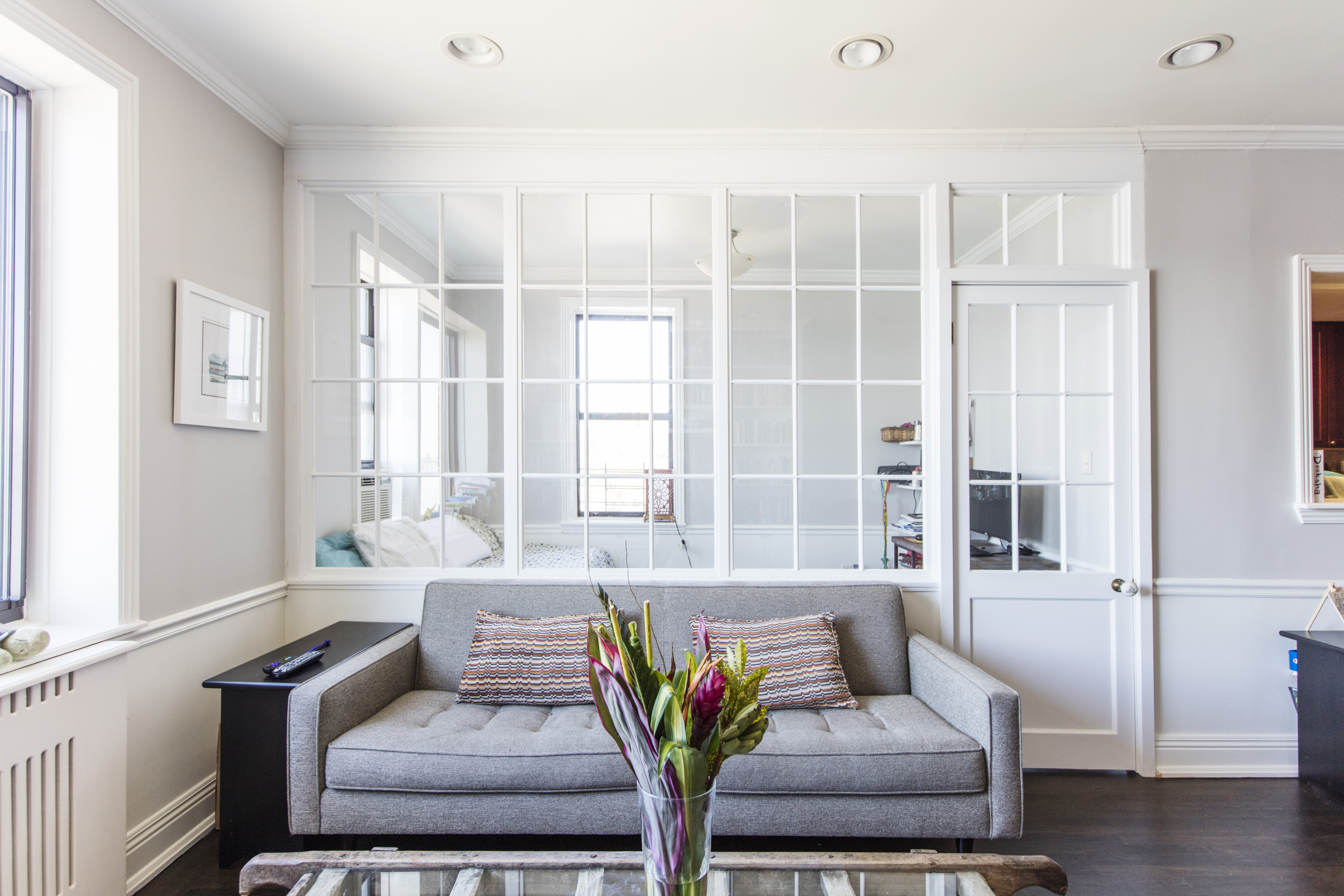 Interior window room divider in Washington Heights separates a guest alcove from the living room while preserving daylight, views, and visual connection.