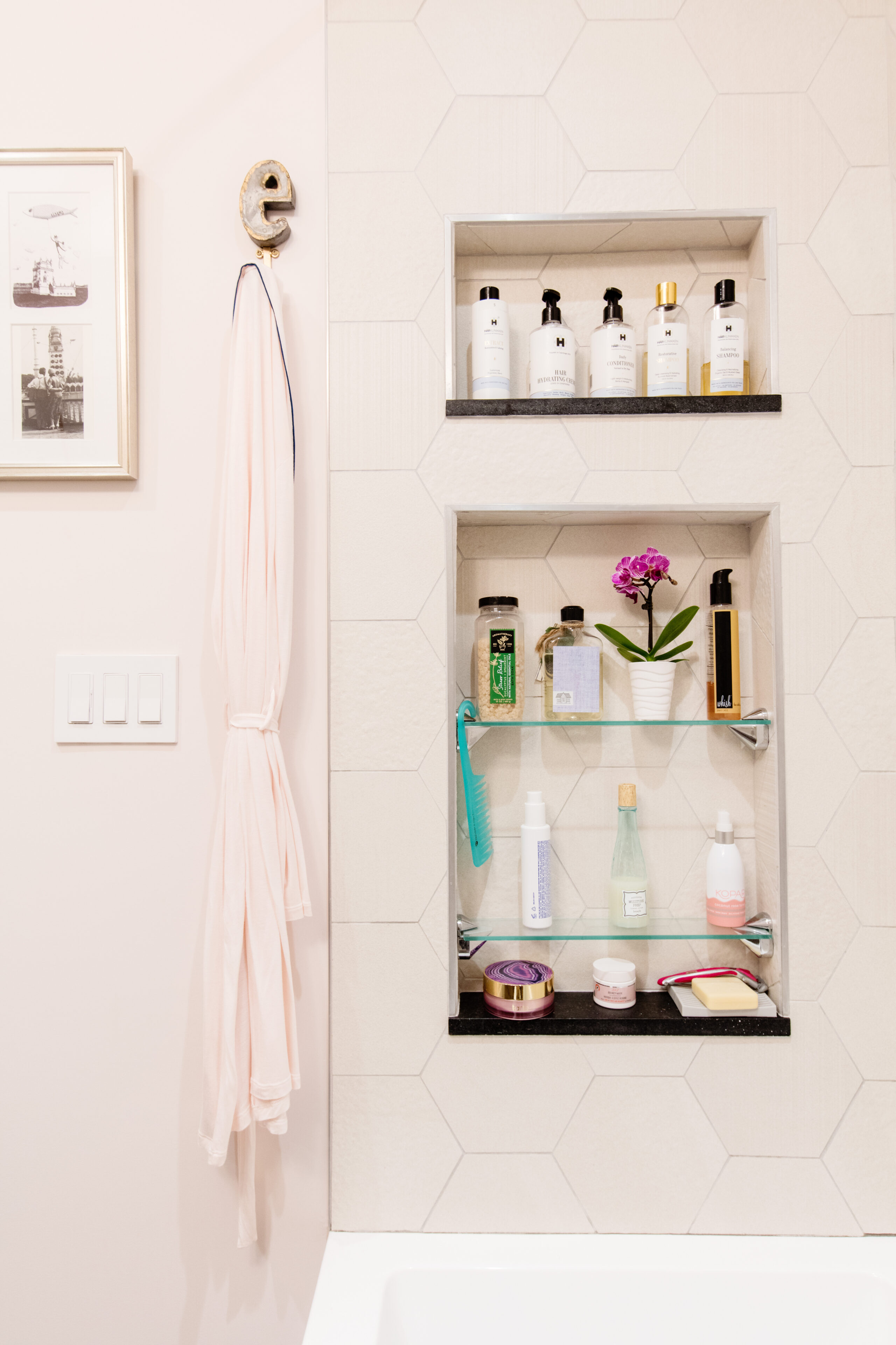 Windsor Terrace bathroom with a decorative cat-shaped robe hook, recessed shower niches, glass shelves, large hex tile, and built-in bath storage.