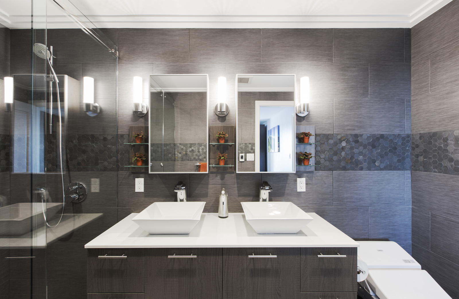 Ditmas Park primary bathroom pairs a double vanity with vessel sinks, twin mirrors, gray textured tile, open glass shelving, and a walk-in shower.