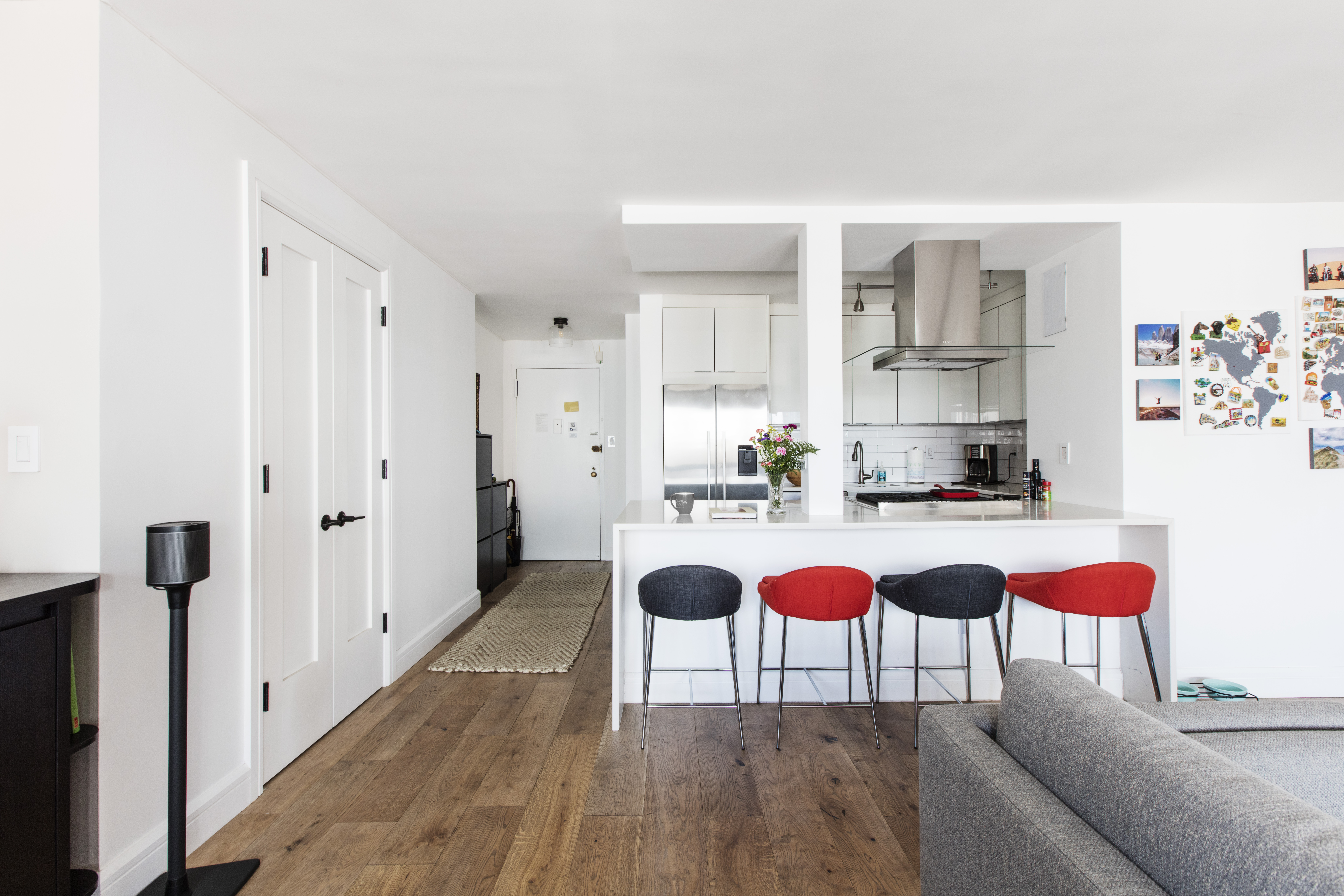 Open plan kitchen living room in the financial district with peninsula seating, wide plank oak flooring, white cabinets and a direct view from room to room.