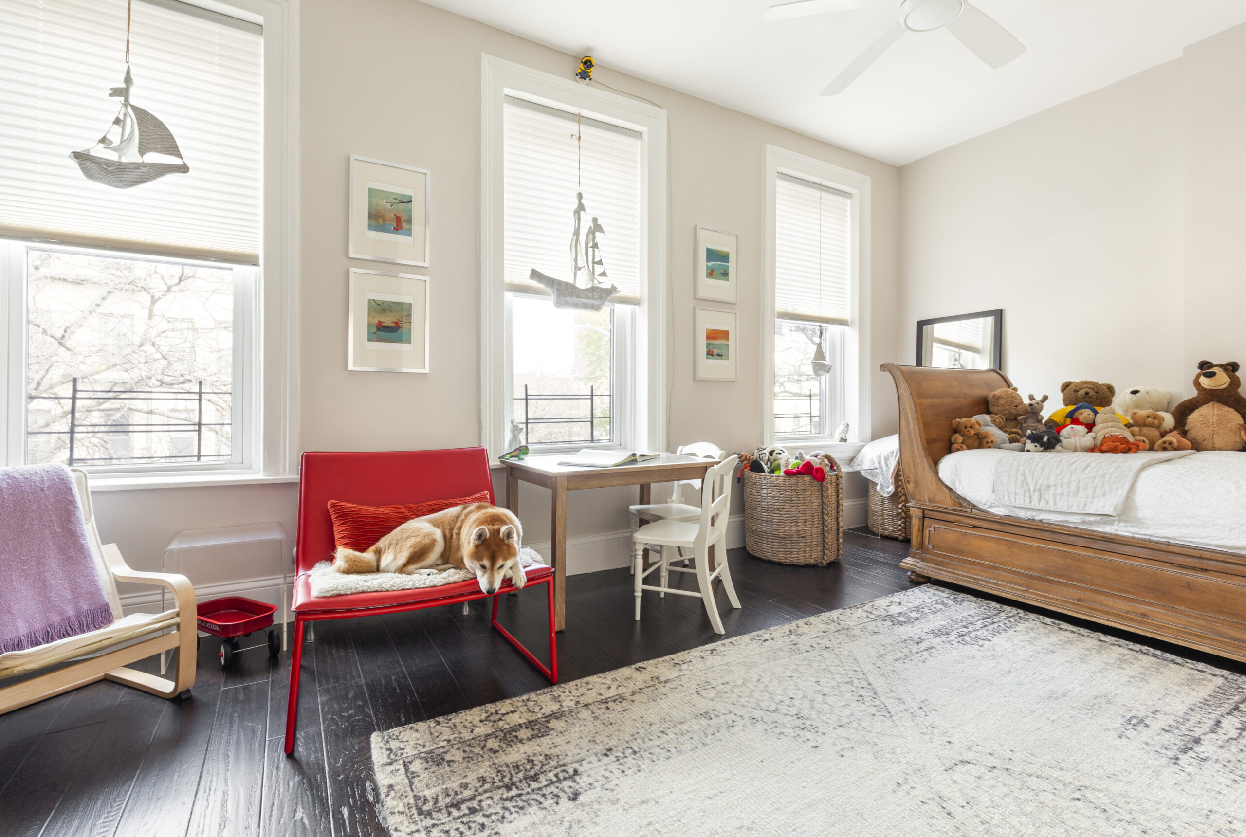 Park Slope townhouse design with a flexible bedroom, dark wood floors, three tall windows, an antique wood daybed, play space, and simple white trim.